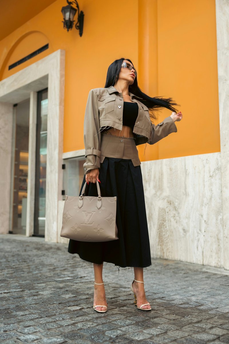 A stylish woman poses outdoors with a designer handbag. photo – Free Woman Image on Unsplash