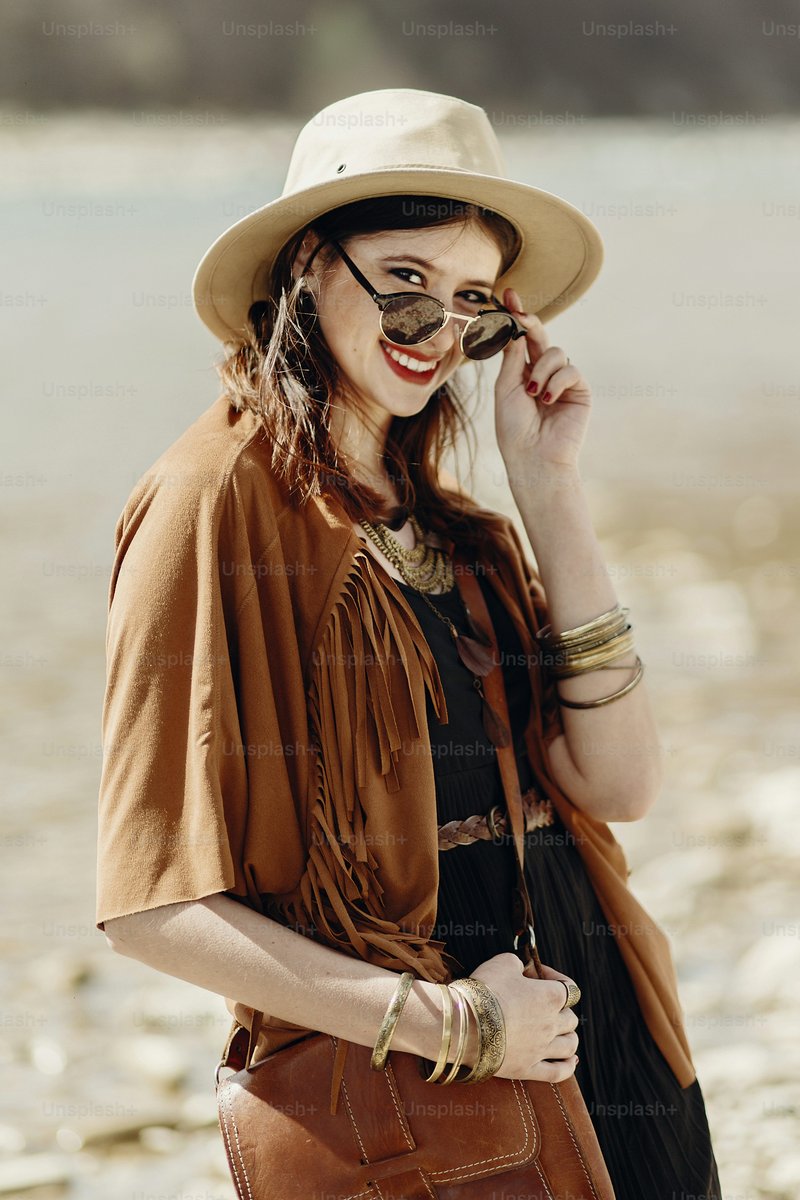 Stylish hipster boho woman smiling in sunglasses with hat, leather bag, fringe poncho and accessory. traveler girl look, near beach in mountains. atmospheric moment. summer travel. photo – Woman Image on Unsplash