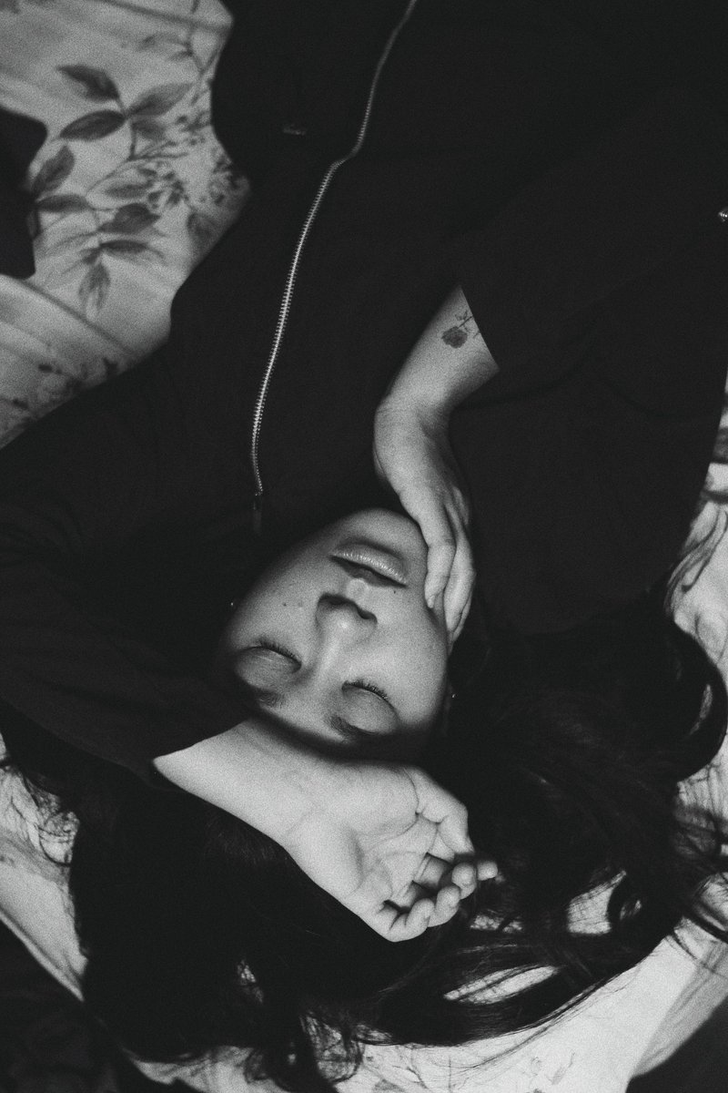 Young thoughtful woman lying on bed with eyes closed · Free ...