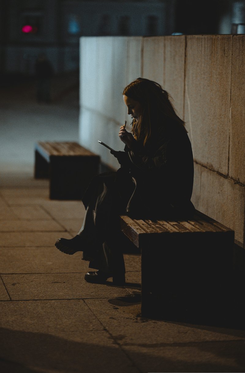 A woman checks her phone in a public space. photo – Free Blue Image on Unsplash