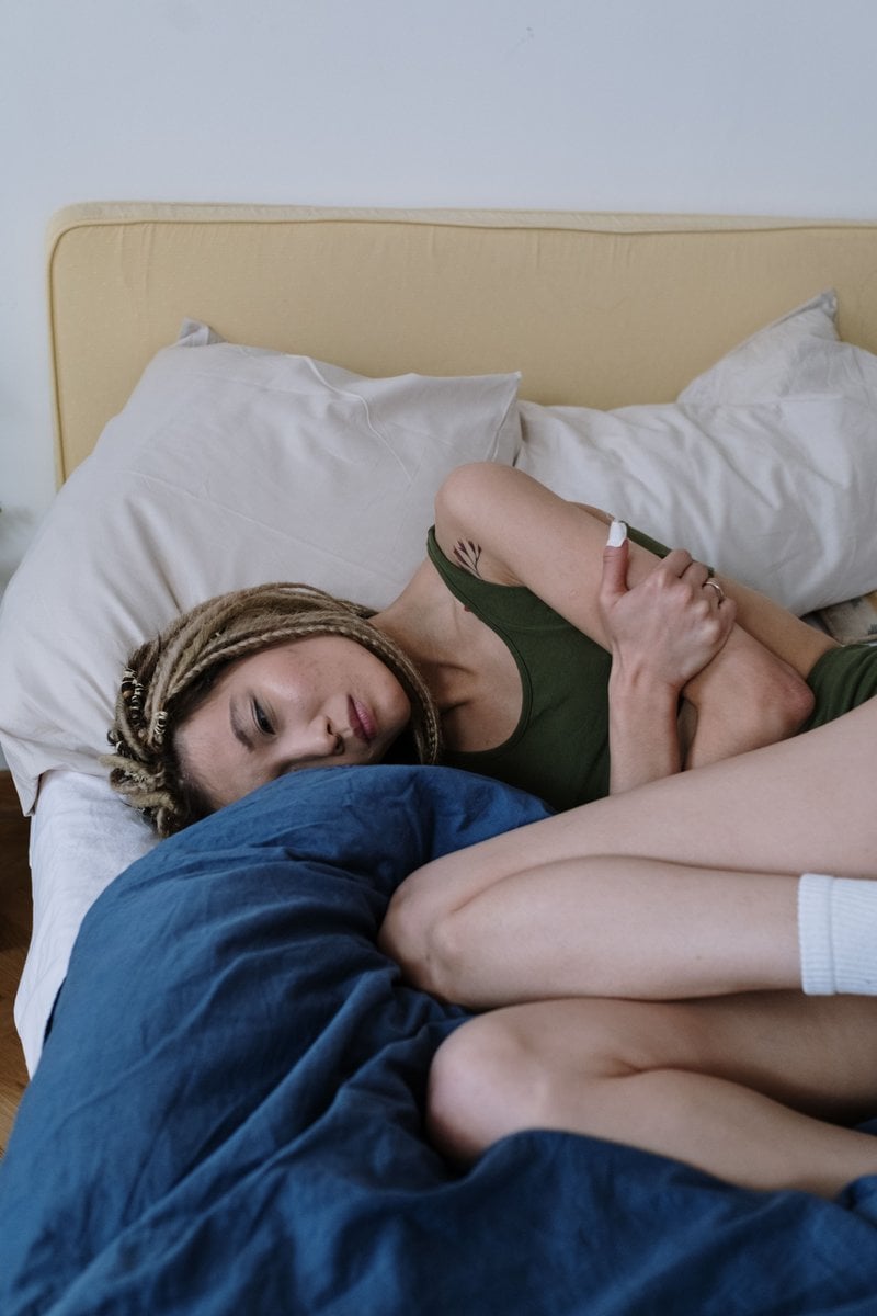 Woman Suffering from a Stomach Pain Lying Down on Bed &middot; Free ...