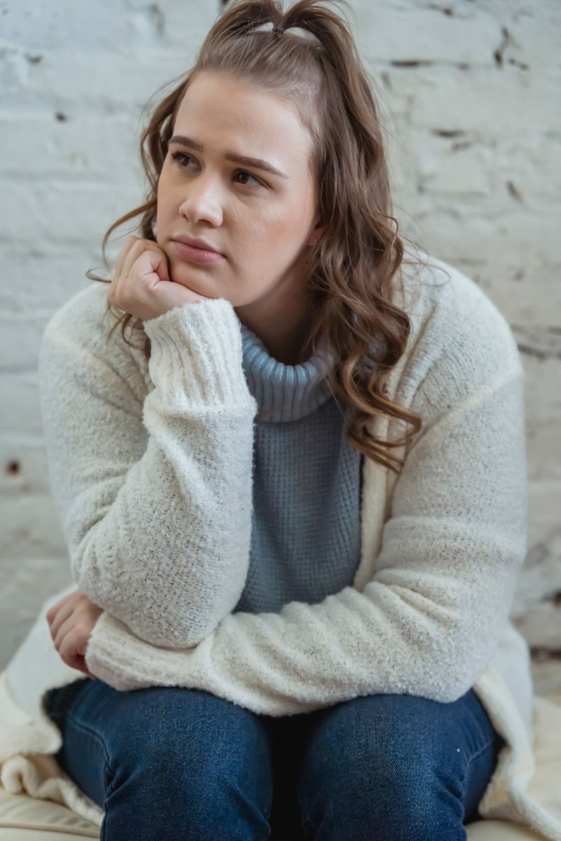 Young woman supporting head with hand and looking away ... Young woman supporting head with hand and looking away ...