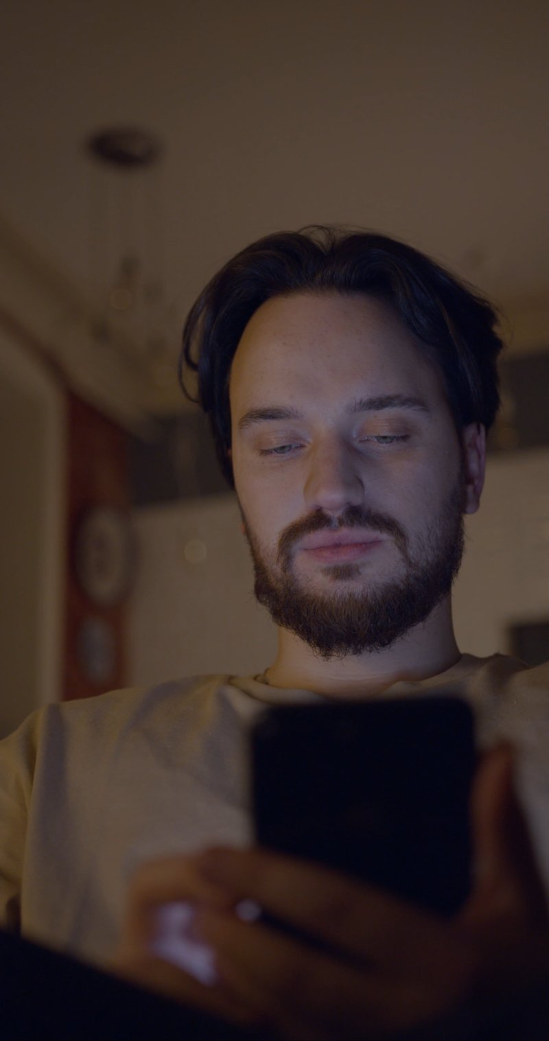 A Man Using His Cellphone With His Wife Peeking Behind A Man Using His Cellphone With His Wife Peeking Behind