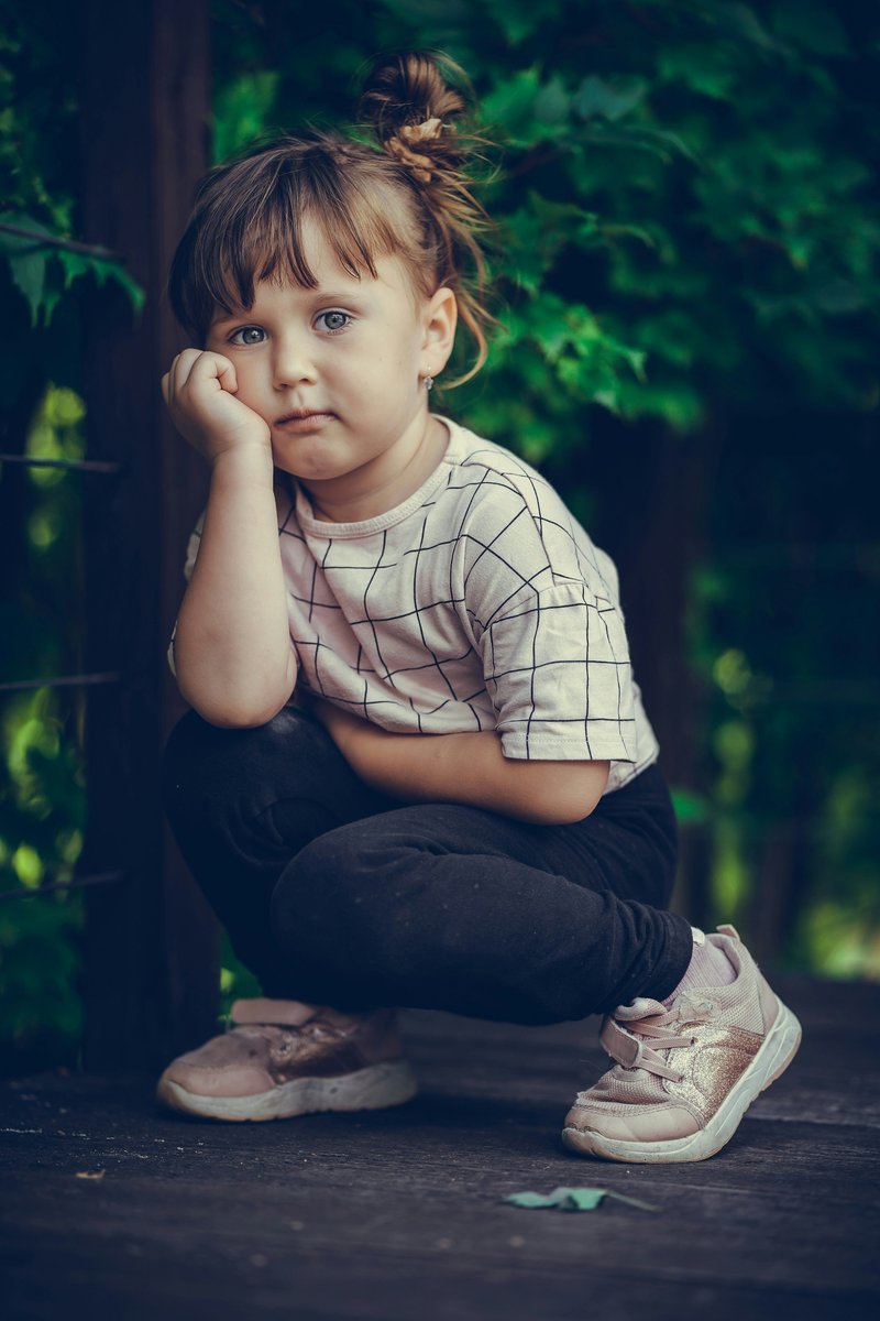 A little girl sitting on the ground with her hand on her face photo &ndash; Free  Black Image on Unsplash