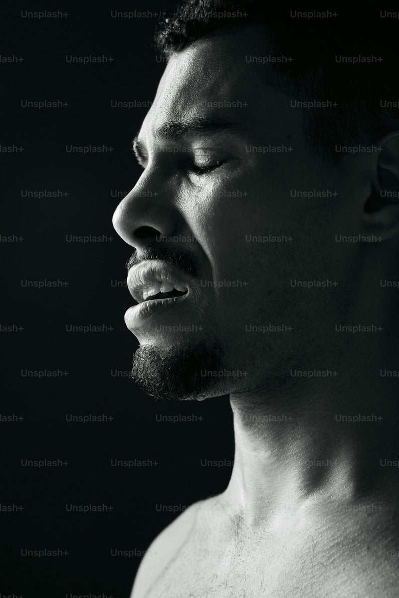A man grimaces with his eyes closed. photo &ndash; Sad Image on Unsplash