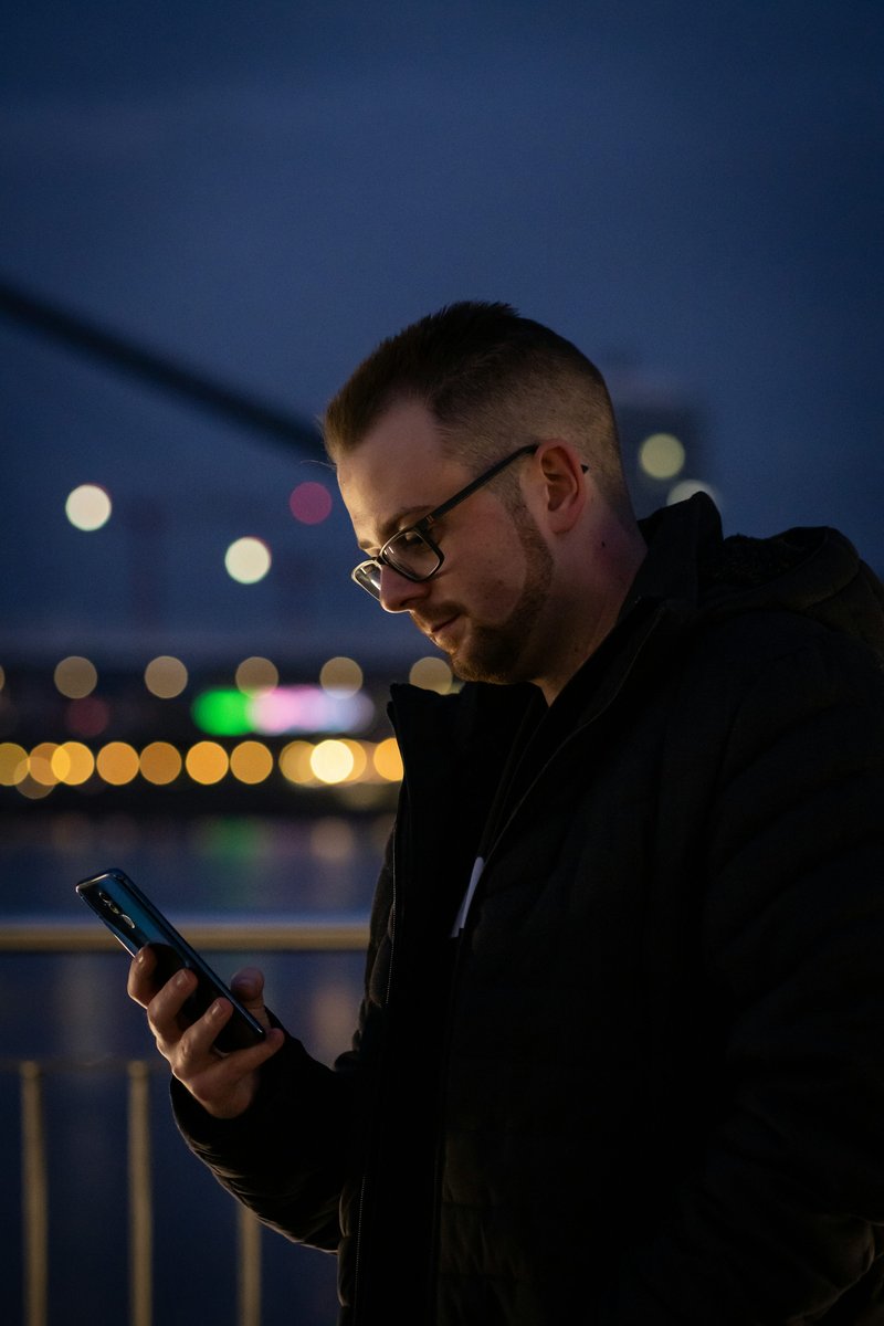 A man looking at his cell phone at night photo – Free Grey Image on Unsplash