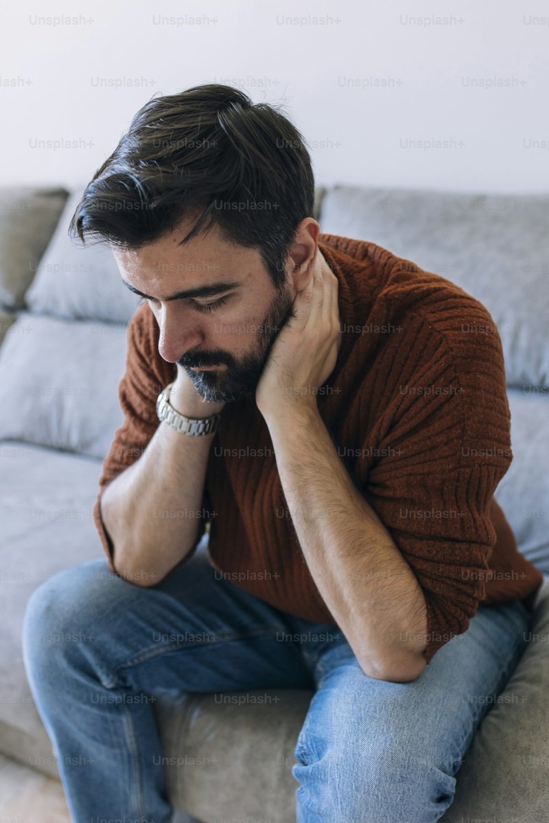 A man sitting on a couch talking on a cell phone photo – Blue Image on Unsplash