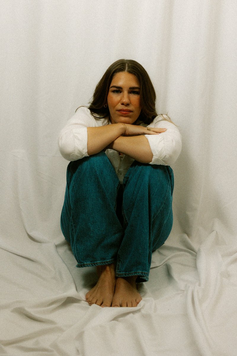 A sad woman sits alone with her arms crossed. photo – Free Purple Image on Unsplash