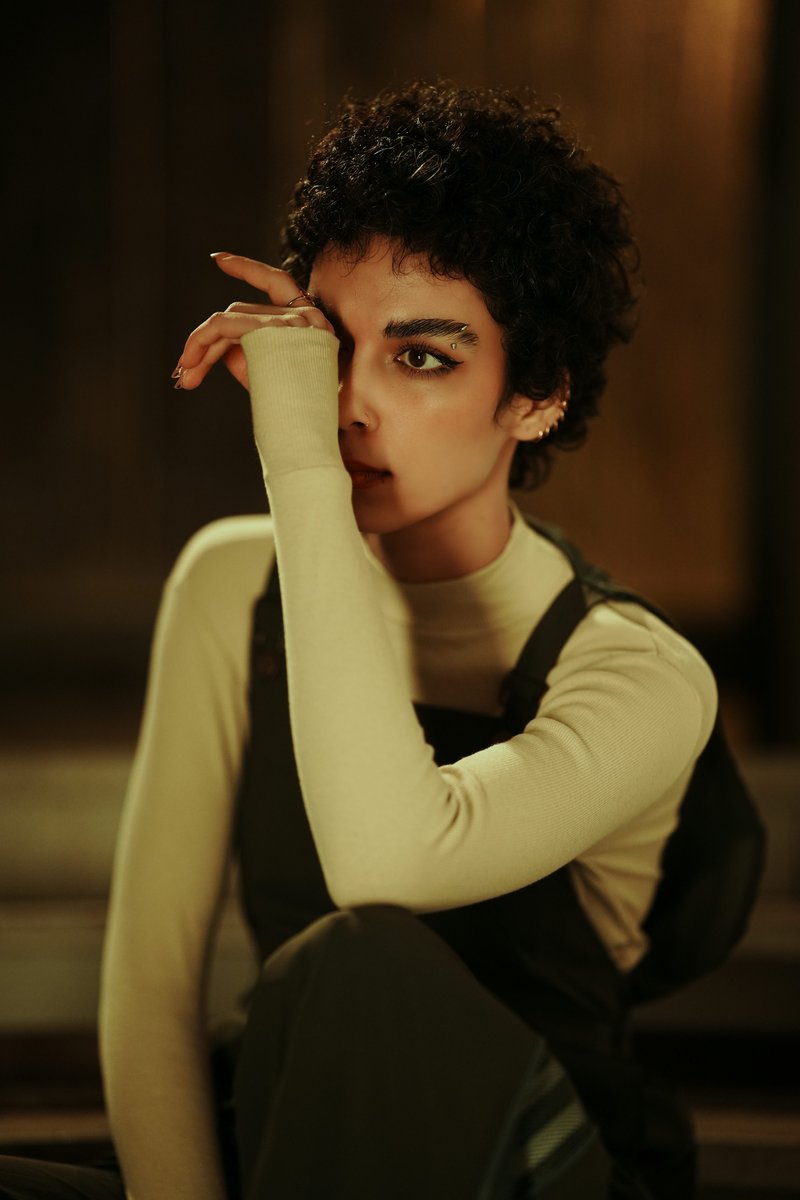 A stylish woman poses with her hand on her face. photo &ndash; Free Green Image  on Unsplash