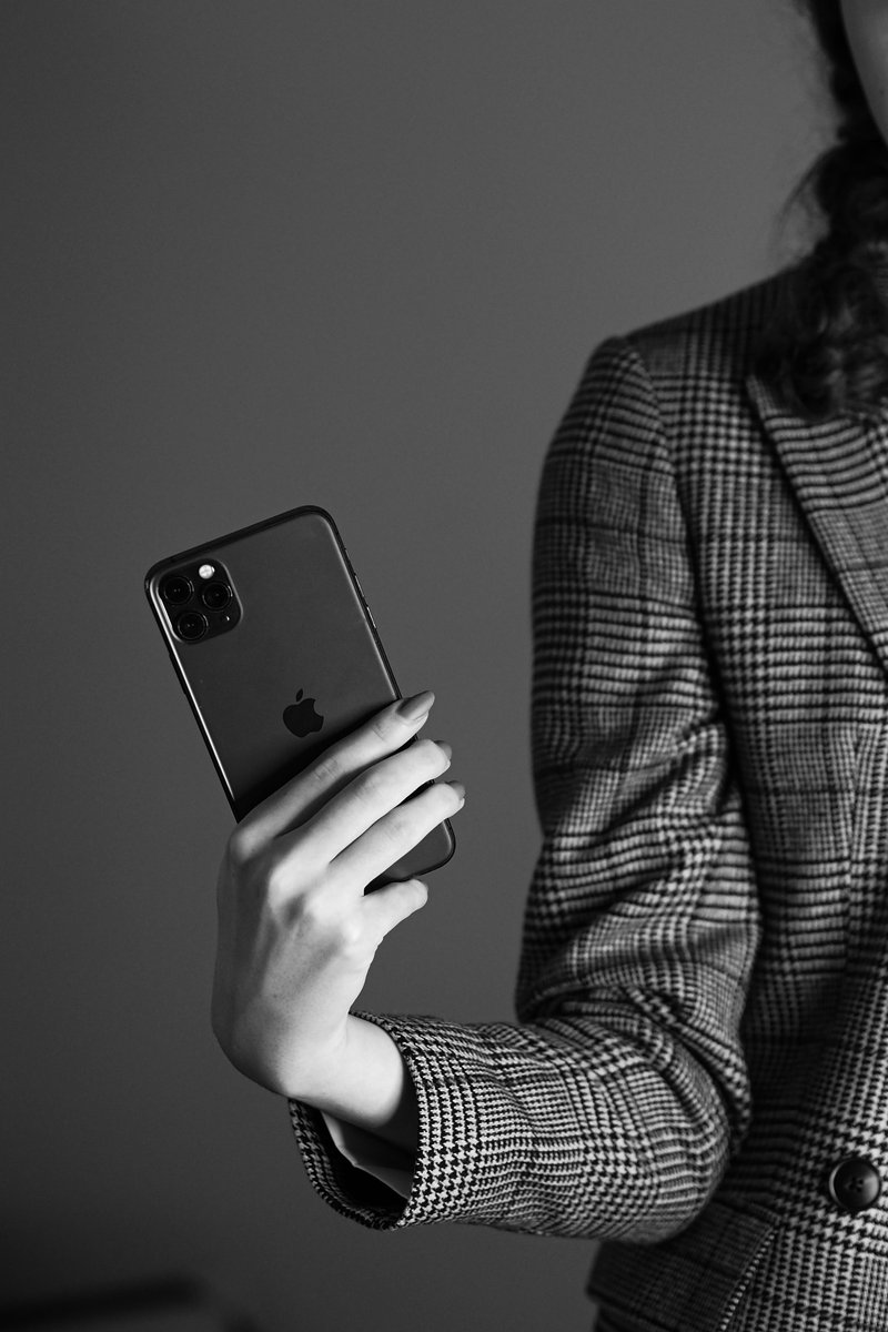 A woman in a suit holding a cell phone photo – Free Grey ...