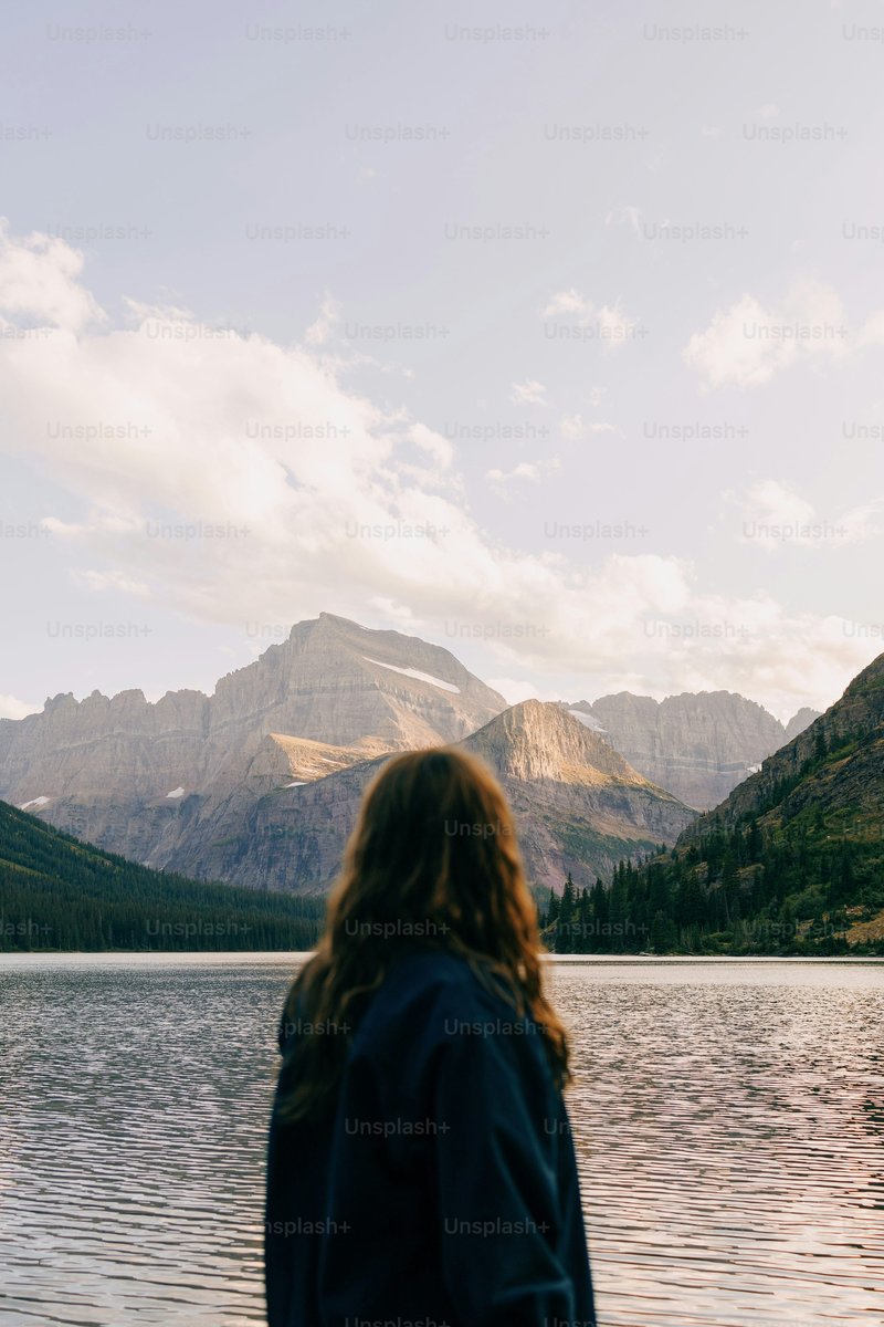A woman standing in front of a lake with mountains in the background photo – Forest Image on Unsplash A woman standing in front of a lake with mountains in the background photo – Forest Image on Unsplash