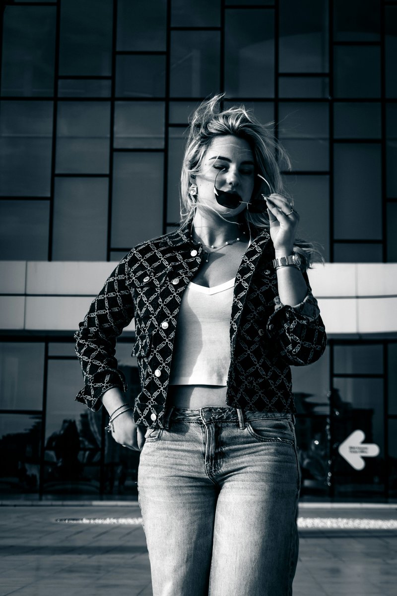 A young woman in sunglasses and jeans stands outside. photo – Free Fashion model Image on Unsplash