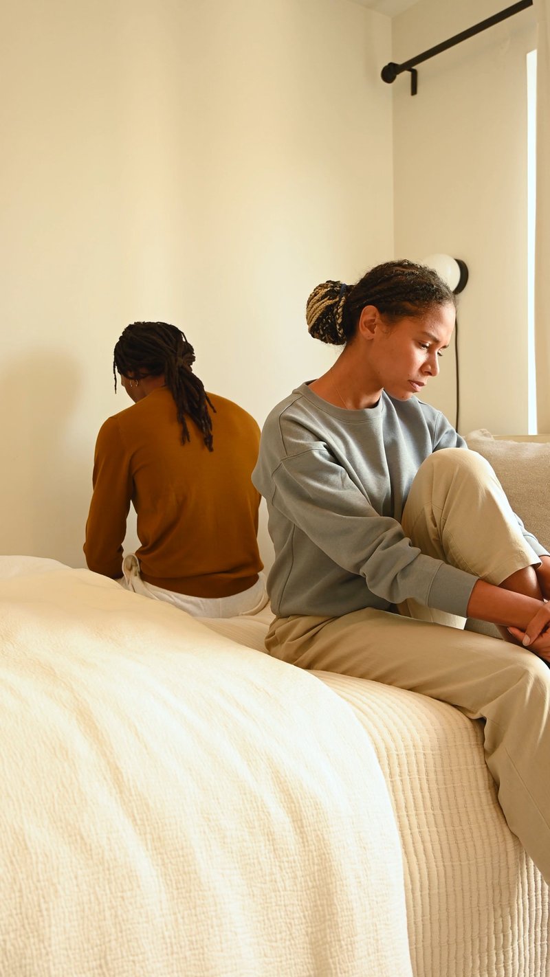 An Upset Couple Sitting on the Bed An Upset Couple Sitting on the Bed