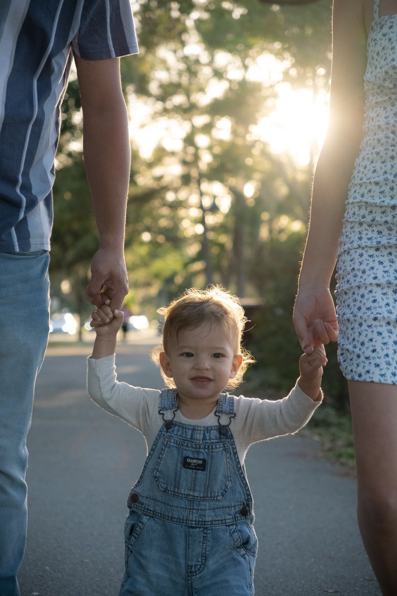 Boy Holding Hands with Mother and Father and Walking at Park &middot; Free Stock  Photo