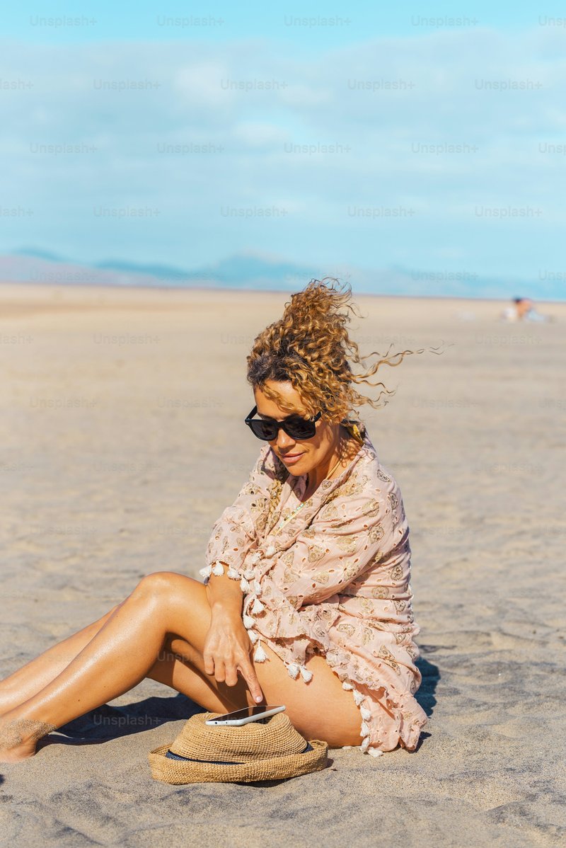 Female tourist relax under the sun in summer holiday vacation day at the  beach using mobile phone. Attractive adult woman enjoy connection outdoors.  Free solo single lady people in tourism activity photo &ndash;
