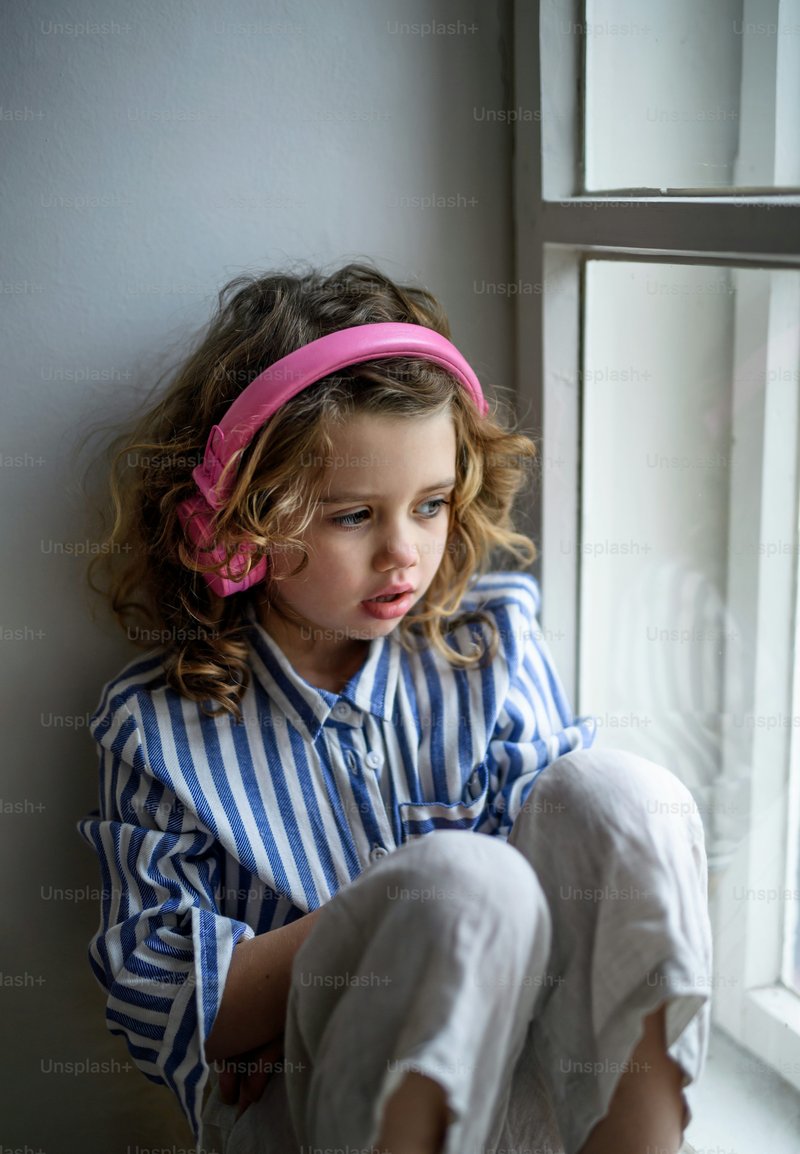 Portrait of sad small girl with headphones indoors at home, sitting on  window sill. photo &ndash; Girl Image on Unsplash