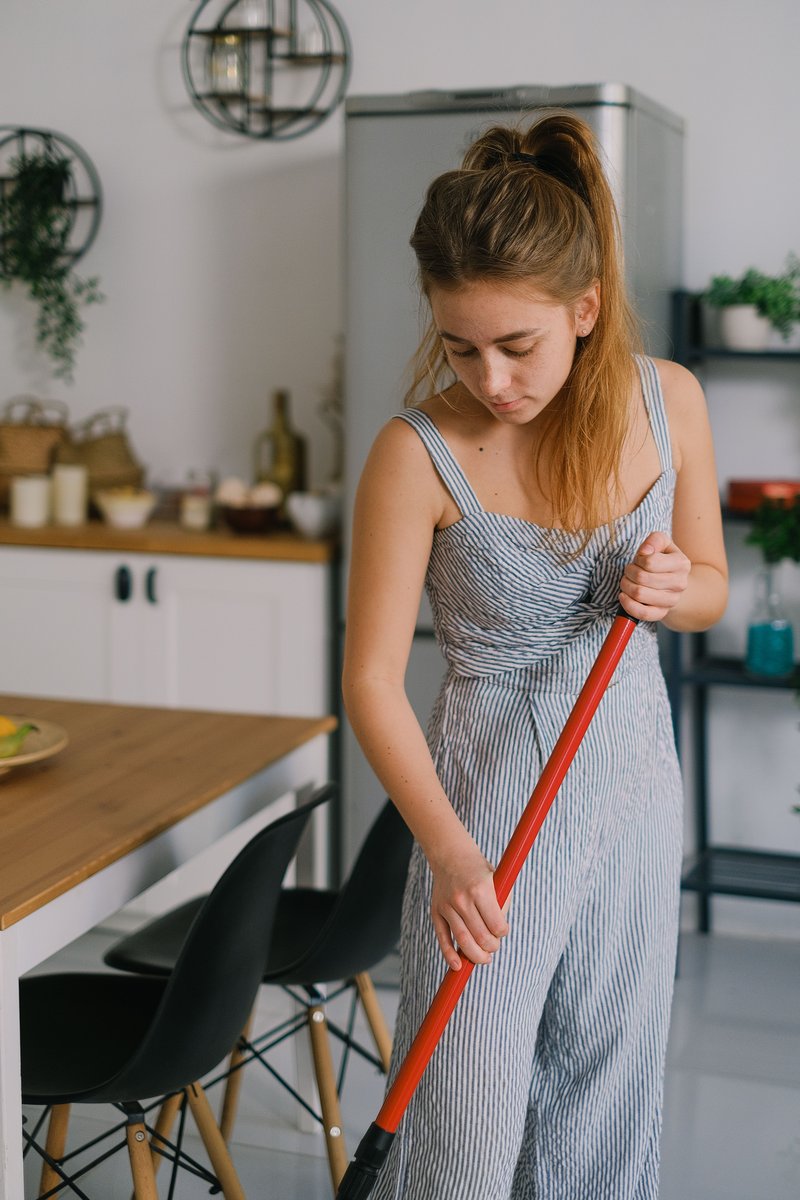 Tired housewife touching head during housework in room · Free Stock Photo