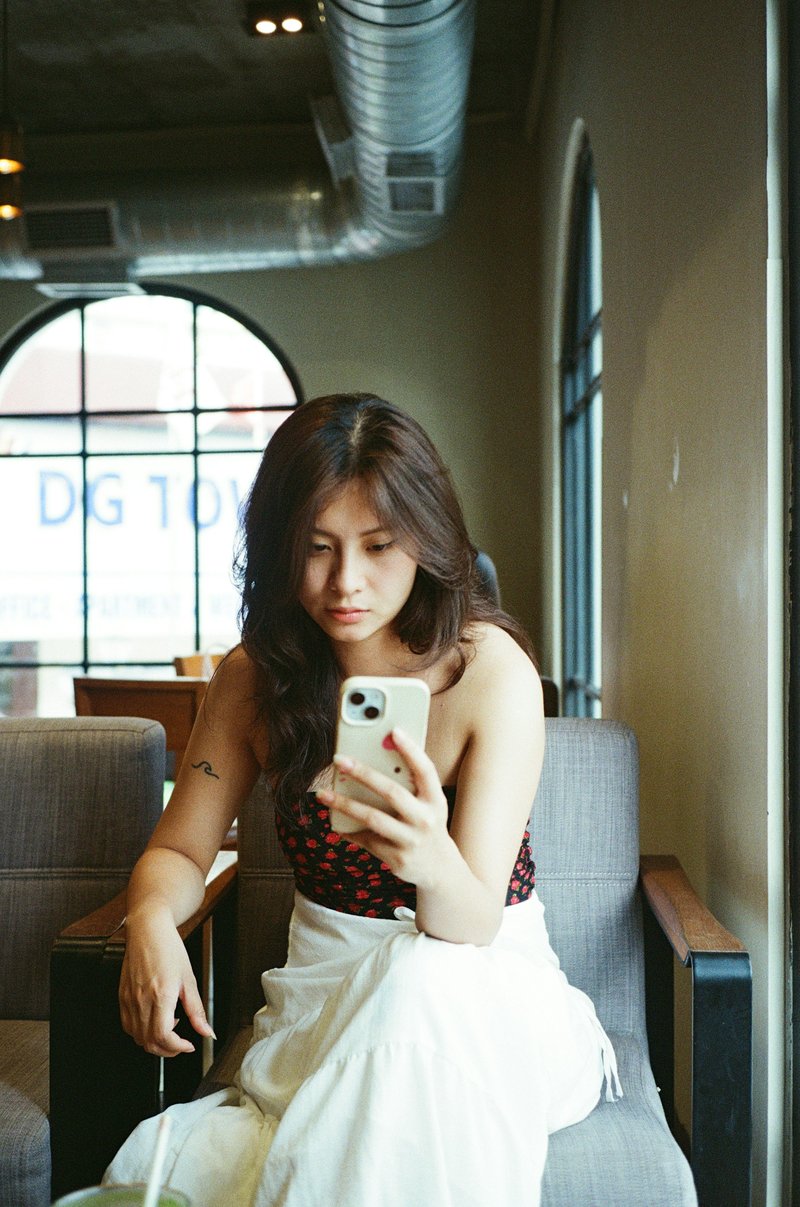 Woman looks at her phone while sitting in a cafe. photo – Free Portrait Image on Unsplash