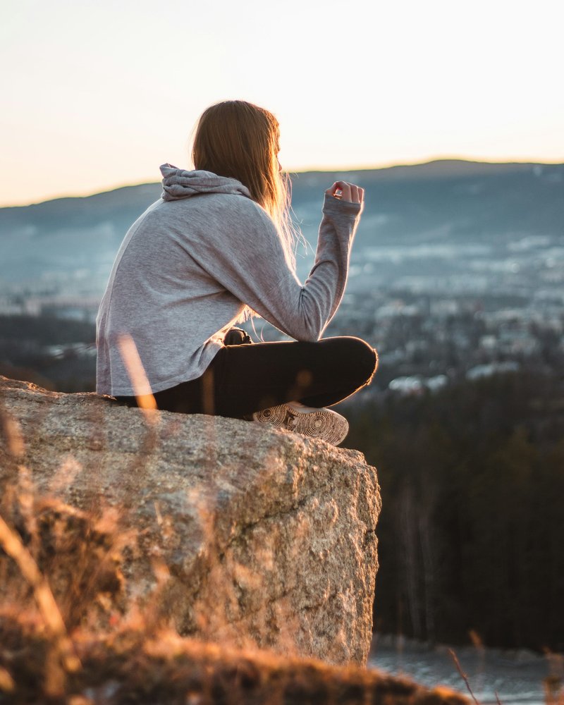 Woman wearing grey hooded jacket sitting on the stone photo ... Woman wearing grey hooded jacket sitting on the stone photo ...