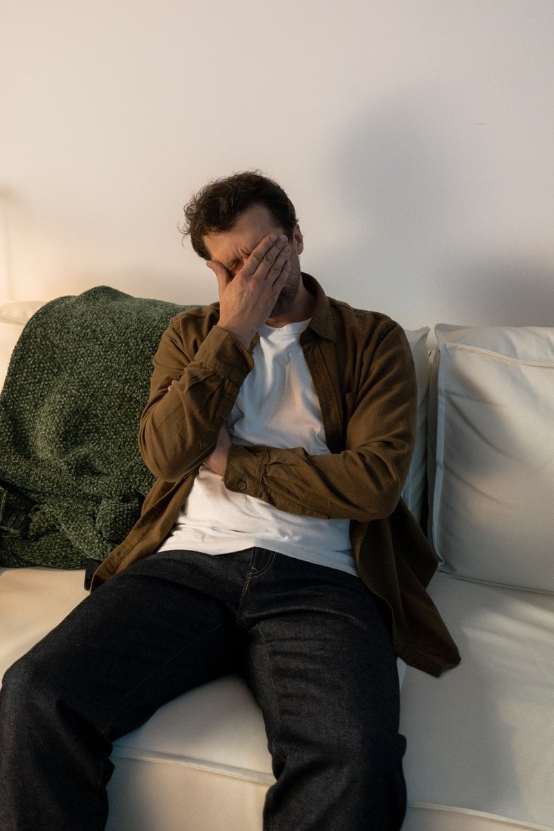 A Distressed Man Sitting on a Couch · Free Stock Photo
