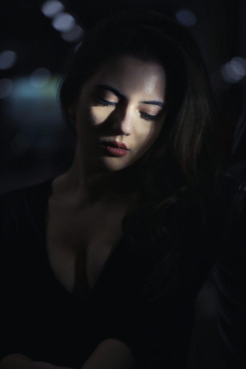 A woman in a dark room looking at her cell phone - Free Photo on Unsplash