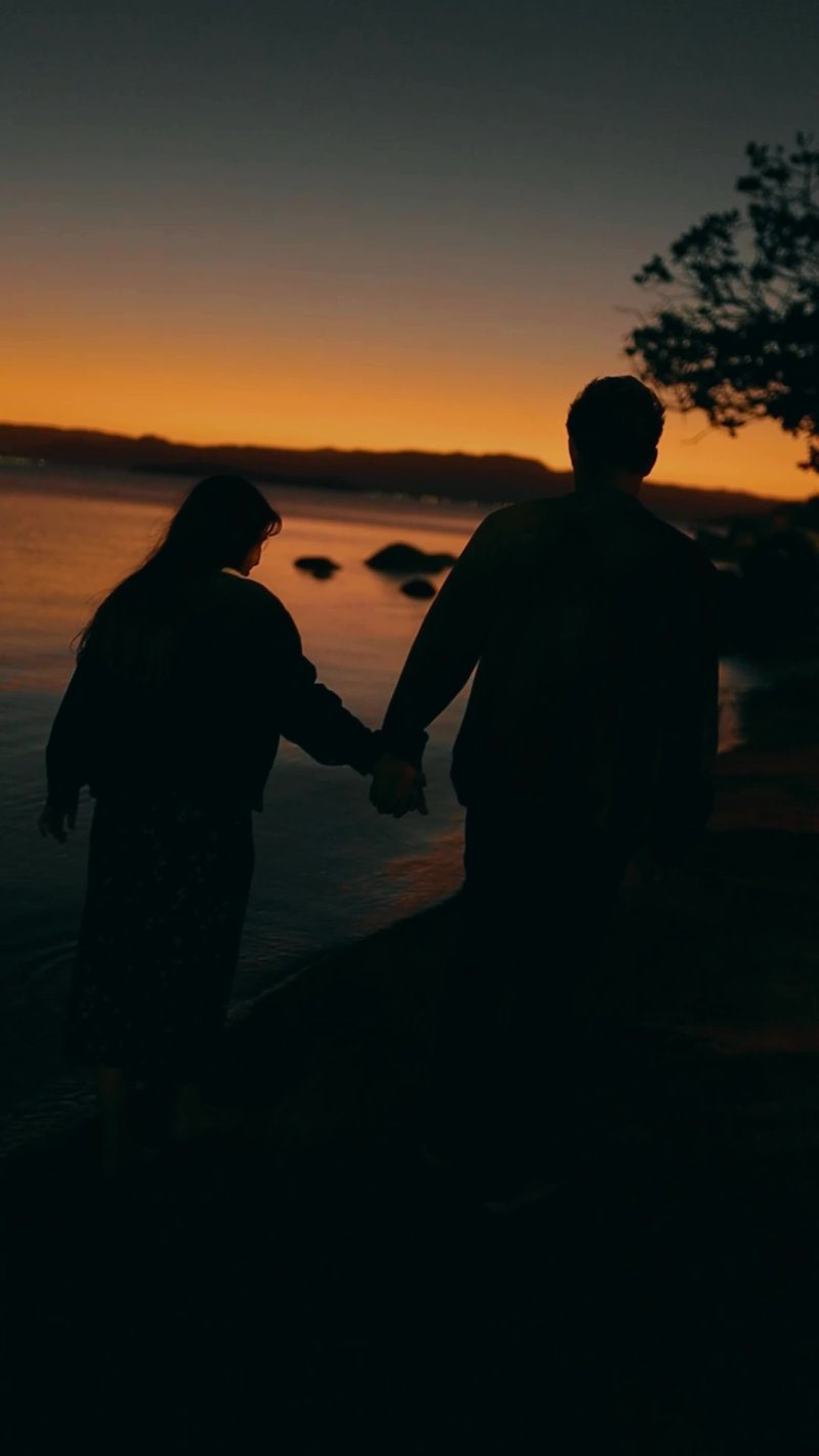 Couple Walking by Lakeside at Sunset