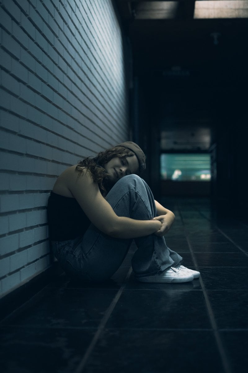 Woman Reflecting Alone in a Dark Hallway &middot; Free Stock Photo