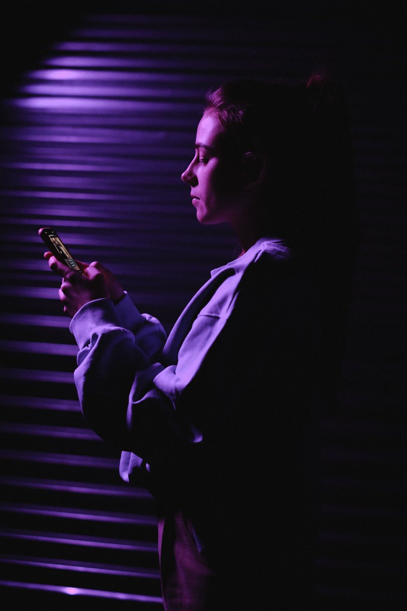 Woman in Sweater Holding Smartphone Illuminated in Purple Light &middot; Free  Stock Photo
